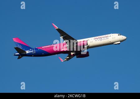 Wizz Air Airbus A321-Flugzeuge, wie sie während des Rollens, des Start- und der Flugphase vom Flughafen Eindhoven WÄHREND eines sonnigen Wintertages am blauen Himmel gesehen werden. W!ZZ Air ist ein ungarischer Ultra Low Cost Airline Carrier mit den größten Stützpunkten am Flughafen Budapest und am Flughafen Luton, der 164 Flughäfen anfliegt. Das Flugzeug A321-200 mit der Logo-Aufschrift auf der Seite hat die Registrierung HA-LXV. Die weltweite Luftfahrtindustrie versucht, sich von den negativen Auswirkungen der Coronavirus-Pandemie Covid-19 zu erholen. Eindhoven, Niederlande am 22. November 2021 (Foto: Nicolas Economou/NurPhoto) Stockfoto