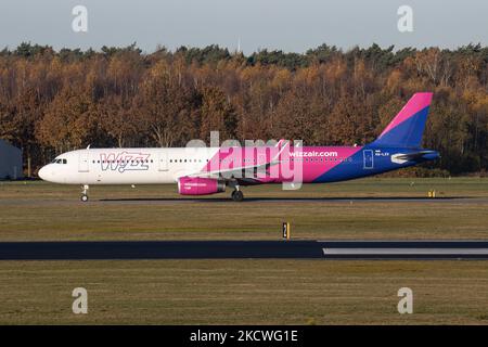 Wizz Air Airbus A321-Flugzeuge, wie sie während des Rollens, des Start- und der Flugphase vom Flughafen Eindhoven WÄHREND eines sonnigen Wintertages am blauen Himmel gesehen werden. W!ZZ Air ist ein ungarischer Ultra Low Cost Airline Carrier mit den größten Stützpunkten am Flughafen Budapest und am Flughafen Luton, der 164 Flughäfen anfliegt. Das Flugzeug A321-200 mit der Logo-Aufschrift auf der Seite hat die Registrierung HA-LXV. Die weltweite Luftfahrtindustrie versucht, sich von den negativen Auswirkungen der Coronavirus-Pandemie Covid-19 zu erholen. Eindhoven, Niederlande am 22. November 2021 (Foto: Nicolas Economou/NurPhoto) Stockfoto