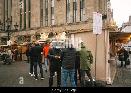 Ein Mitarbeiter überprüft den digitalen Impfpass vor einem Weihnachtsmarkt in Düsseldorf am 25. Nov 2021 (Foto: Ying Tang/NurPhoto) Stockfoto