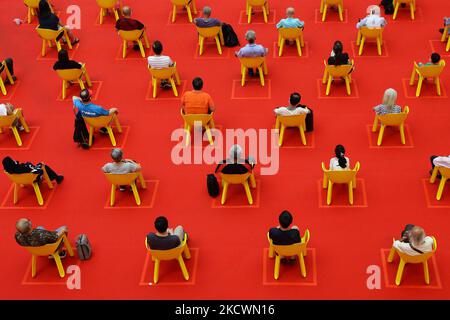 Menschen sitzen auf einem Stuhl, um die soziale Distanzierung inmitten der COVID-19-Pandemie am 27. November 2021 in Singapur aufrechtzuerhalten. (Foto von Suhaimi Abdullah/NurPhoto) Stockfoto