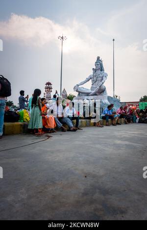 Juli 4. 2022 Haridwar Indien. Lord Shiva Statue am Haridwar Bahnhof mit Leuten, die überall auf der Wartehalle sitzen. Stockfoto