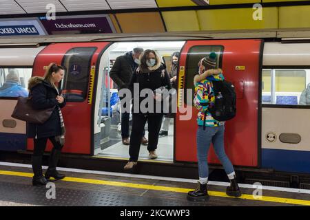 LONDON, VEREINIGTES KÖNIGREICH - 29. NOVEMBER 2021: Pendler, einige mit Gesichtsschutz, reisen mit der Londoner U-Bahn, bevor Maßnahmen zur Verlangsamung der Ausbreitung des neuen Coronavirus Omicron eingeführt werden, das am 29. November 2021 in London, England, übertragbarer zu sein scheint. Ab morgen werden Gesichtsbedeckungen in Geschäften und öffentlichen Verkehrsmitteln in England verpflichtend, PCR-Tests werden bei Einreisen in das Vereinigte Königreich wieder eingeführt, und Kontakte von Verdachtsfällen müssen sich unabhängig vom Impfstatus selbst isolieren. (Foto von Wiktor Szymanowicz/NurPhoto) Stockfoto