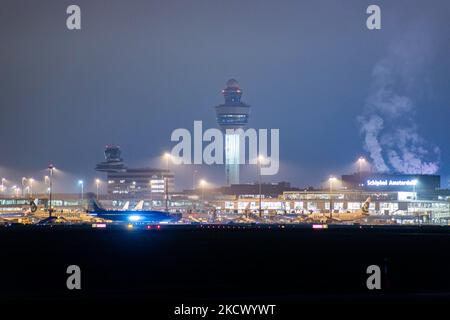 Nachtansicht des Flughafens Amsterdam Schiphol AMS mit Flugzeugen vor den Toren. 14 Fälle der neuen COVID-19-Variante Omicron wurden in den Niederlanden von Passagieren bestätigt, die aus Südafrika in die niederländische Stadt kamen. Mehr als 600 Passagiere wurden von den 2 Flügen getestet, wobei 61 positiv für Covid-19 bestätigt wurden. Die niederländische Polizei verhaftete zuvor zwei Passagiere, die sich in einem Quarantänehotel aufgehalten haben, als sie versuchten zu entkommen. Viele Länder haben Flüge nach Südafrika während einer bereits schwierigen Zeit mit der Coronavirus-Pandemie, die sich negativ auf die Luftfahrtindustrie auswirkte, eingestellt. Stockfoto