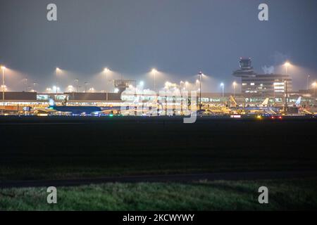 Nachtansicht des Flughafens Amsterdam Schiphol AMS mit Flugzeugen vor den Toren. 14 Fälle der neuen COVID-19-Variante Omicron wurden in den Niederlanden von Passagieren bestätigt, die aus Südafrika in die niederländische Stadt kamen. Mehr als 600 Passagiere wurden von den 2 Flügen getestet, wobei 61 positiv für Covid-19 bestätigt wurden. Die niederländische Polizei verhaftete zuvor zwei Passagiere, die sich in einem Quarantänehotel aufgehalten haben, als sie versuchten zu entkommen. Viele Länder haben Flüge nach Südafrika während einer bereits schwierigen Zeit mit der Coronavirus-Pandemie, die sich negativ auf die Luftfahrtindustrie auswirkte, eingestellt. Stockfoto