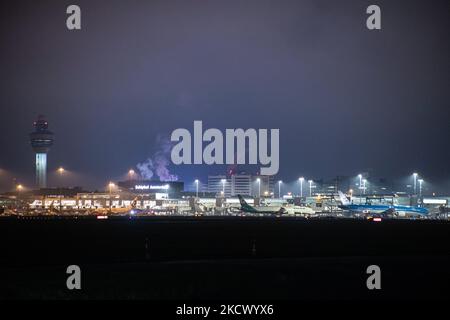 Nachtansicht des Flughafens Amsterdam Schiphol AMS mit Flugzeugen vor den Toren. 14 Fälle der neuen COVID-19-Variante Omicron wurden in den Niederlanden von Passagieren bestätigt, die aus Südafrika in die niederländische Stadt kamen. Mehr als 600 Passagiere wurden von den 2 Flügen getestet, wobei 61 positiv für Covid-19 bestätigt wurden. Die niederländische Polizei verhaftete zuvor zwei Passagiere, die sich in einem Quarantänehotel aufgehalten haben, als sie versuchten zu entkommen. Viele Länder haben Flüge nach Südafrika während einer bereits schwierigen Zeit mit der Coronavirus-Pandemie, die sich negativ auf die Luftfahrtindustrie auswirkte, eingestellt. Stockfoto