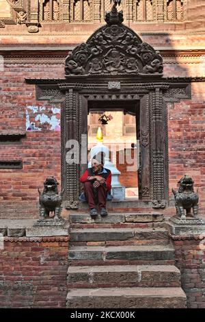 In der mittelalterlichen Stadt Bhaktapur in Nepal sitzt ein älterer Tempelhüter am Eingang eines alten buddhistischen Tempels. (Foto von Creative Touch Imaging Ltd./NurPhoto) Stockfoto