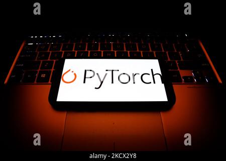 Das PyTorch-Logo auf einem Telefonbildschirm und einer Laptop-Tastatur ist auf diesem Bild zu sehen, das am 1. Dezember 2021 in Krakau, Polen, aufgenommen wurde. (Foto von Jakub Porzycki/NurPhoto) Stockfoto