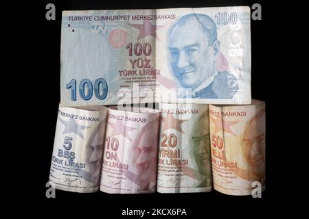 Foto Illustration von türkischen Lira-Banknoten auf schwarzem Hintergrund und einem Maßband als Symbol für die schrumpfende Wirtschaft und Währung. Die Lira erreicht ein neues Rekordtief, da die Währung die Verluste für den Handel über 13,73 pro US-Dollar und 15,51 Euro ausdehnte. Die türkische Lira rutscht auf ein Rekordtief, nachdem Präsident Erdogan die Leitzinspolitik verdoppelt hat. Illustration der türkischen Lira-Banknoten, die Währung der Türkei, in türkischer Sprache Türk Lira genannt, mit dem Zeichen: Und Code TRY oder TL. Auf der Vorderseite des Gesetzentwurfs sind Porträts von Mustafa Kemal Atatürk zu sehen. Amsterdam, Niederlande am 33. Dezember 2021. (Foto von Nicol Stockfoto