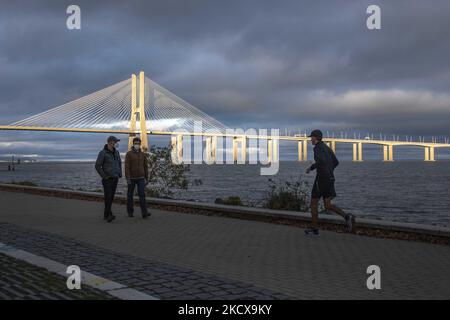 Menschen mit Schutzmasken führen Outdoor-Aktivitäten auf der Promenade des Flusses Tejo in der Nähe der Vasco de Gama-Brücke in Lissabon durch. 04. Dezember 2021. Portugal verzeichnete erneut eine übermäßige Sterblichkeit aufgrund von Covid 19. Der November endete mit 1.265 Todesfällen mehr als im Durchschnitt der Jahre 2017 bis 2019. Ein Viertel der Todesfälle wurde durch Covid verursacht. Das Mortality Surveillance System, das Sterbeurkunden in Echtzeit analysiert, verzeichnet einen Überschuss an Todesfällen in den letzten 11 Tagen. (Foto von Jorge Mantilla/NurPhoto) Stockfoto