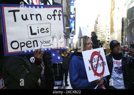 Demonstranten hören Rednern auf dem Times Square zu, die am 5,2021. Dezember in New York City, USA, gegen Impfungen gegen Covid-19 vorgehen. Nach einer Rede und einem Lied von einem Aktivisten skandierten Menschen mehrmals „Wir werden uns nicht halten“. (Foto von John Lamparski/NurPhoto) Stockfoto