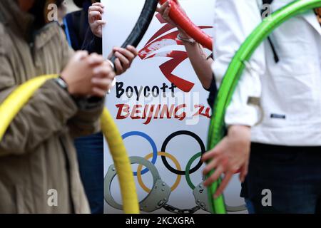 Die Protestierenden werden an die Olympischen Ringe gefesselt, wobei einer ein Schild mit der Aufschrift Boykott Beijing hält, während eines Protestes zur Boykottierung der Winterspiele 2022 in Peking vor der Bank of China (Zweigstelle Taipei) in Taipei, Taiwan, am 10. Dezember 2021. Die Vereinigten Staaten, Kanada, Großbritannien und Australien haben zugesagt, nach dem Verschwinden des chinesischen Tennisspielers Peng Shuai und den Menschenrechtsverletzungen gegen Hongkong und Xinjiang keine Beamten zur Teilnahme an den Spielen zu entsenden, um China zu boykottieren. (Foto von Ceng Shou Yi/NurPhoto) Stockfoto