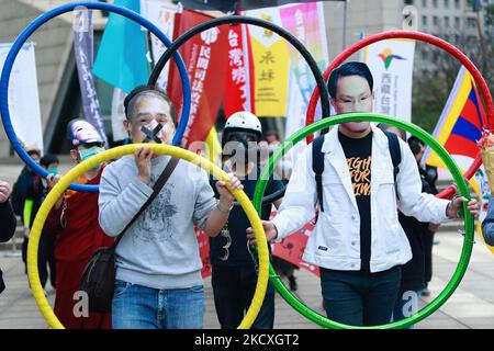 Protestler, der die Olympischen Ringe während eines Boykottens der Winterspiele 2022 in Peking vor der Bank of China (Niederlassung Taipei) in Taipei, Taiwan, am 10. Dezember 2021 hielt. Die Vereinigten Staaten, Kanada, Großbritannien und Australien haben zugesagt, nach dem Verschwinden des chinesischen Tennisspielers Peng Shuai und den Menschenrechtsverletzungen gegen Hongkong und Xinjiang keine Beamten zur Teilnahme an den Spielen zu entsenden, um China zu boykottieren. (Foto von Ceng Shou Yi/NurPhoto) Stockfoto