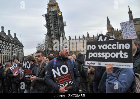 Demonstranten halten am 11. Dezember 2021 in London, Vereinigtes Königreich, Schilder vor dem Parlamentsgebäude hoch. Auf dem Parliment Square findet ein kleiner Protest statt, um gegen die Möglichkeit zu demonstrieren, dass die britische Regierung sogenannte Impfpass-Pässe eindunziert (Foto: Jay Shaw Baker/NurPhoto) Stockfoto