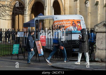 LONDON, VEREINIGTES KÖNIGREICH – 13. DEZEMBER 2021: Die Menschen warten darauf, ihre Jabs in einem Covid-19-Impfbus vor der St. Luke's & Christ Church in Chelsea zu empfangen, da die Einführung von Auffrischungsimpfstoffen diese Woche auf alle Erwachsenen in England ausgeweitet wird, um den Anstieg der Omicron-Coronavirus-Fälle am 13. Dezember 2021 in London, England, zu bekämpfen. Gestern kündigte der britische Premierminister Boris Johnson den Plan der Regierung an, bis zum Neujahr allen Erwachsenen Auffrischungsimpfungen in Höhe von durchschnittlich 1 Millionen Dosen pro Tag zu liefern, da der britische Covid-Alarm aufgrund des schnellen Anstiegs i auf Stufe 4 erhöht wurde Stockfoto