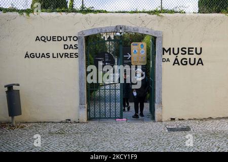 Eine Person geht in der Nähe des Eingangs zum Aguas Livres Museum, Lissabon. 05. Dezember 2021. Das Aquädukt Ãguas Livres oder das Freiwasser-Aquädukt ist eine von König Juan V. entworfene Struktur für die Trinkwasserverteilung in der Stadt Lissabon. Obwohl er im 19.. Jahrhundert fertiggestellt wurde, lieferte er bis 1748 Wasser in die Stadt.der Hauptkanal misst 19 km, Obwohl die Gesamtlänge einschließlich der Sekundärkanäle 58 km beträgt. Der bekannteste Teil sind die 35 Bögen über dem Tal, von denen der höchste 65 Meter hoch ist. Die öffentliche Straße über das Aquädukt ist seit 1853 teilweise gesperrt Stockfoto
