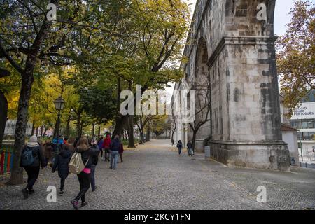 Die Menschen gehen in der Nähe der Bögen, die entlang der Hauptstraße des Aquädukts Aguas Livres in Lissabon verlaufen. 05. Dezember 2021. Das Aquädukt Ãguas Livres oder das Freiwasser-Aquädukt ist eine von König Juan V. entworfene Struktur für die Trinkwasserverteilung in der Stadt Lissabon. Obwohl er im 19.. Jahrhundert fertiggestellt wurde, lieferte er bis 1748 Wasser in die Stadt.der Hauptkanal misst 19 km, Obwohl die Gesamtlänge einschließlich der Sekundärkanäle 58 km beträgt. Der bekannteste Teil sind die 35 Bögen über dem Tal, von denen der höchste 65 Meter hoch ist. Die öffentliche Straße über das Aquädukt wurde cl Stockfoto