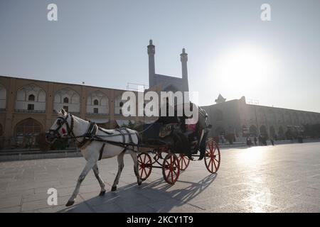 Eine Pferdekutsche fährt am 14. Dezember 2021 nach dem Ausbruch des neuen Coronavirus (COVID-281 19) an der Imam-Moschee auf dem historischen Platz Naghsh e Jahan in der Stadt Isfahan, 450 km südlich von Teheran, vorbei. Ein Sprecher der Isfahan University of Medical Sciences sagte: „Gemäß der jüngsten epidemischen Färbung der Covid-19-Krankheit befand sich die Metropole Isfahan in einem blauen (risikoarmen) Zustand, was proportional zur Abnahme der Anzahl positiver Koronartests und hospitalisierter Menschen ist.“ Laut einer Nachricht der Iranian Students News Agency (ISNA). (Foto von Morteza Nik Stockfoto