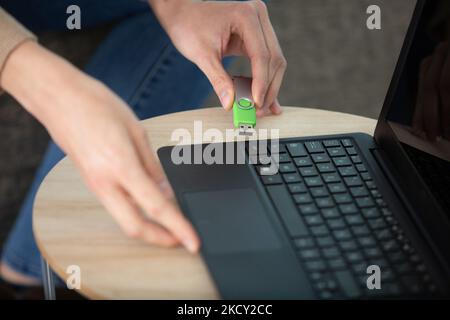 Handanschluss eines Pendrives in einem Laptop auf einem Desktop Stockfoto