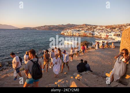 Die Menschen fotografieren den Sonnenuntergang von der Windmühlengegend in Mykonos Stadt. Touristen genießen einen wunderschönen Sonnenuntergang während der magischen Stunde auf der Insel Mykonos in Griechenland. Die griechische Insel Myconos ist ein beliebtes glamouröses mediterranes Reiseziel für einen Urlaub in den Kykladen, der Ägäis mit den ikonischen weiß getünchten Gebäuden, den Sandstränden und berühmten Partys an den Strandbars. Die Tourismus- und Reisebranche hatte aufgrund der Coronavirus-Pandemie Covid-19 negative Auswirkungen auf die Wirtschaft und die lokale Wirtschaft. Mykonos, Griechenland am 10. Oktober 2021 (Foto von Nicolas Economou/NurPhoto) Stockfoto