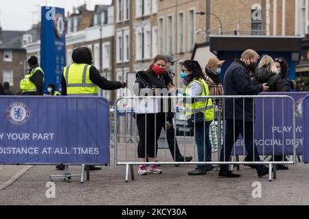 LONDON, VEREINIGTES KÖNIGREICH - 18. DEZEMBER 2021: Die Menschen kommen zu einem Covid-19-Massenimpfzentrum im Stamford Bridge-Stadion des FC Chelsea, das am Tag des 18. Dezember 2021 in London, England, 10.000 Jabs verabreichen soll. Veranstaltungsorte im ganzen Land bereiten sich darauf vor, an diesem Wochenende eine Rekordzahl von Booster-Shots zu liefern, um den Schutz der Menschen vor der Omicron-Variante vor Weihnachten zu verbessern, da Großbritannien gestern 93.045 Covid-19-Infektionen gemeldet hat, eine Rekordzahl am dritten Tag in Folge. (Foto von Wiktor Szymanowicz/NurPhoto) Stockfoto