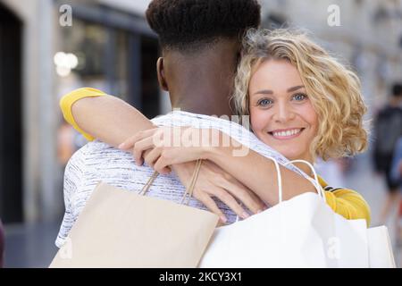 Paar umarmte und hielt Einkaufstaschen Stockfoto
