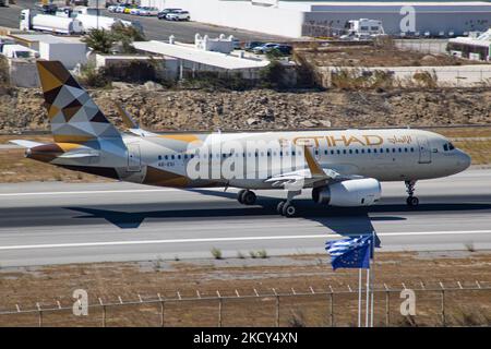 Etihad Airways Airbus A320 Flugzeuge wie gesehen Rollen, starten und fliegen von Mykonos Airport JMK. Das Flugzeug mit der Registrierung A6-EIU bringt den Passagier nach dem Start zum Flughafen Abu Dhabi. Etihad ist die zweite Fluggesellschaft der Vereinigten Arabischen Emirate. Die griechische Insel Myconos ist ein beliebtes glamouröses mediterranes Reiseziel für einen Urlaub in den Kykladen, der Ägäis mit den ikonischen weiß getünchten Gebäuden, den Sandstränden und berühmten Partys an den Strandbars. Die Luftfahrt-, Reise-, Freizeit-, Tourismus- und Geschäftsbranche sowie der Personenverkehr haben mit dem Co eine schwierige Phase eingemaust Stockfoto