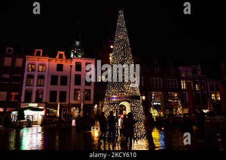 Eine Gruppe von Menschen fotografiert eine der acht Lichtskulpturen, die in der Stadt Nijmegen aufgestellt wurden, um die Menschen während der härteren Sperre, die am selben Nachmittag, am 18.. Dezember, in Nijmegen, verhängt wurde, aufzumuntern. (Foto von Romy Arroyo Fernandez/NurPhoto) Stockfoto