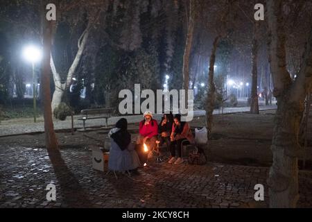 Eine iranische Familie sitzt am 14. Dezember 2021 nachts in einem Park in der Nähe eines ausgetrockneten Flusses Zayandeh Rud in der Stadt Isfahan, 450 km (281 Meilen) südlich von Teheran, um das Feuer herum. Ein Sprecher der Isfahan University of Medical Sciences sagte: „Gemäß der jüngsten epidemischen Färbung der Covid-19-Krankheit befand sich die Metropole Isfahan in einem blauen (risikoarmen) Zustand, was proportional zur Abnahme der Anzahl positiver Koronartests und hospitalisierter Menschen ist.“ Laut einer Nachricht der Iranian Students News Agency (ISNA). (Foto von Morteza Nikoubazl/NurPhoto) Stockfoto