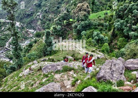 Schulmädchen gehen in Uniform auf einem verräterischen Steinweg, der durch den Dschungel führt und hoch in die Berge führt, während sie 3-4 Stunden (zweimal täglich) von ihrem abgelegenen Bergdorf zur Schule und zurück zu ihrem Zuhause hoch in den Bergen in Himachal Pradesh fahren, Indien. (Foto von Creative Touch Imaging Ltd./NurPhoto) Stockfoto