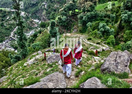 Schulmädchen gehen in Uniform auf einem verräterischen Steinweg, der durch den Dschungel führt und hoch in die Berge führt, während sie 3-4 Stunden (zweimal täglich) von ihrem abgelegenen Bergdorf zur Schule und zurück zu ihrem Zuhause hoch in den Bergen in Himachal Pradesh fahren, Indien. (Foto von Creative Touch Imaging Ltd./NurPhoto) Stockfoto