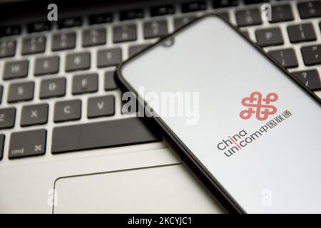 In dieser Abbildung ist ein China Unicom-Logo zu sehen, das am 30. Dezember 2021 in Athen, Griechenland, auf einem Smartphone-Bildschirm mit einem Computerschlüsselwort im Hintergrund angezeigt wird. (Foto von Nikolas Kokovlis/NurPhoto) Stockfoto