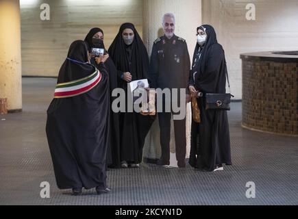 Verschleierte iranische Frauen posieren für Fotos mit einem Bildnis des führenden iranischen IRGC-Kommandanten, General Qasem Soleimani, der bei einem US-Drohnenangriff in Bagdad im Azadi (Freedom) Sportkomplex getötet wurde, während er am 1. Januar 2022 an einer Zeremonie zum Todesjahr von Soleimani im Westen Teheran teilnahm. Iran anlässlich des zweiten Todestages des ehemaligen Kommandeurs des Quds-Militärs der Islamischen Revolutionsgarde (IRGC), General Qasem Soleimani, der bei einem US-Drohnenangriff auf dem internationalen Flughafen Bagdad im Irak getötet wurde. (Foto von Morteza Nikoubazl/NurPhoto) Stockfoto