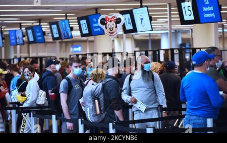 2. Januar 2022 - Orlando, Florida, USA - Reisende warten am 2. Januar 2022 in Orlando, Florida, an einem TSA-Sicherheitskontrollpunkt am internationalen Flughafen Orlando in der Schlange. Urlaubsreisen wurden von Tausenden von gestrichenen und verspäteten Flügen in den Vereinigten Staaten geplagt, die durch schlechtes Wetter und Mangel an Flugbesatzungen aufgrund der COVID-19 Omicron-Variante verursacht wurden. (Foto von Paul Hennessy/NurPhoto) Stockfoto