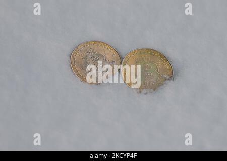 Illustratives Bild von zwei Gedenkbitcoins im Schnee. Am Montag, den 3. Januar 2021, Kanada. (Foto von Artur Widak/NurPhoto) Stockfoto