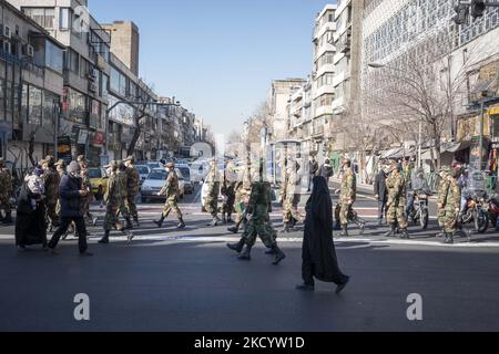 Militärangehöriger der iranischen Armee überqueren während einer Beerdigung für den Iran-Irak-Krieg (1980-88) unbekannte Märtyrer am 6. Januar 2022 in der Innenstadt von Teheran eine Straße. Tausende von Iranern nehmen an einer Beerdigung für den Iran-Irak-Krieg 150 (1980 1988-88) Teil, die von der iranischen Märtyrer-Untersuchungsgruppe 34 Jahre nach einem Waffenstillstand zwischen dem Iran und dem Irak im Kriegshauptfeld gefunden wurde. (Foto von Morteza Nikoubazl/NurPhoto) Stockfoto