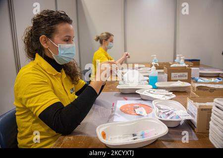 Eine GGD-Mitarbeiterin im Gesundheitswesen bereitet die Pfizer - BioNTech Covid-19-Impfstoffe vor, die sie aus der Fläschchenglasflasche zu den Spritzen im Sonderbereich des Mega-Impfzentrums in Eindhoven zieht. Die Jabs werden als Booster-Schuss verabreicht. Der dritte Dosisverstärker ist für alle in den Niederlanden verfügbar, zusätzlich zur Sperrung, da das Land gegen Ausbrüche der neuen omicron-Variante-Coronavirus-Mutation der Pandemie kämpft. Eindhoven, Niederlande am 7. Januar 2022 (Foto: Nicolas Economou/NurPhoto) Stockfoto