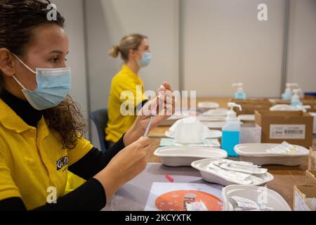Eine GGD-Mitarbeiterin im Gesundheitswesen bereitet die Pfizer - BioNTech Covid-19-Impfstoffe vor, die sie aus der Fläschchenglasflasche zu den Spritzen im Sonderbereich des Mega-Impfzentrums in Eindhoven zieht. Die Jabs werden als Booster-Schuss verabreicht. Der dritte Dosisverstärker ist für alle in den Niederlanden verfügbar, zusätzlich zur Sperrung, da das Land gegen Ausbrüche der neuen omicron-Variante-Coronavirus-Mutation der Pandemie kämpft. Eindhoven, Niederlande am 7. Januar 2022 (Foto: Nicolas Economou/NurPhoto) Stockfoto