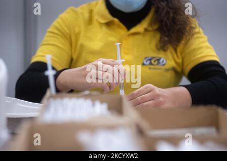 Eine GGD-Mitarbeiterin im Gesundheitswesen bereitet die Pfizer - BioNTech Covid-19-Impfstoffe vor, die sie aus der Fläschchenglasflasche zu den Spritzen im Sonderbereich des Mega-Impfzentrums in Eindhoven zieht. Die Jabs werden als Booster-Schuss verabreicht. Der dritte Dosisverstärker ist für alle in den Niederlanden verfügbar, zusätzlich zur Sperrung, da das Land gegen Ausbrüche der neuen omicron-Variante-Coronavirus-Mutation der Pandemie kämpft. Eindhoven, Niederlande am 7. Januar 2022 (Foto: Nicolas Economou/NurPhoto) Stockfoto
