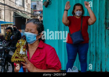 Anhänger von Black Nazarene besuchen die Quiapo Church in Manila, Philippinen, am Festtag, dem 9. Januar 2022. Aufgrund der plötzlichen Zunahme von COVID-19-Fällen mit Omicron-Variantenbedrohung auf den Philippinen, die die Regierung dazu veranlasst, die Alarmstufe 3 in der National Capital Region neu zu verhängen, hebt die Quiapo Church in Manila die jährliche Tradition, Traslacion von Anhängern von Black Nazarene, auf, um die Massensammlung und Ausbreitung des Coronavirus zu vermeiden. Trotz der genannten Richtlinien versuchen hingebungsvolle katholiken immer noch, die verbarrikadierte Kirche zu erreichen, um ihre persönlichen Gebete darzubieten. (Foto von Ryan Eduard Benaid/NurPhoto) Stockfoto