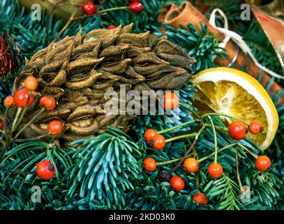 Weihnachtsdekoration, festliche Komposition mit natürlichen Kiefernzweigen, Kegel, Beeren und Kugeln. Schöne Luxus Ornament von Weihnachtsbaum Stockfoto