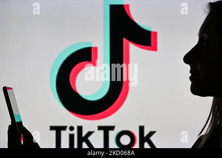 Ein Bild einer Frau, die ein Mobiltelefon vor ein TikTok-Logo hält, das auf einem Computerbildschirm angezeigt wird. Am Dienstag, den 12. Januar 2021, Kanada. (Foto von Artur Widak/NurPhoto) Stockfoto