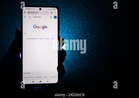 Hand hält ein Smartphone mit dem angezeigten Google-Logo und dunkelblauem Hintergrund. Google-Closeup-Logo auf einem Telefonbildschirm, Smartphone das Logo oder die Suchmaschine in verschiedenen Hintergründen wie Tastatur, dunkel beleuchtete Textur oder ein Computerbildschirm angezeigt, wie in dieser Multiple-Exposure-Illustration gesehen, das Unternehmenssymbol ist weltweit anerkannt. Google, LLC ist ein amerikanischer Tech-Gigant, ein multinationales Technologieunternehmen, das sich auf internetbezogene Dienste und Produkte spezialisiert hat, zu denen Online-Werbetechnologien, eine Suchmaschine, Cloud-Computing, Software und Hardware gehören. Es ist c Stockfoto