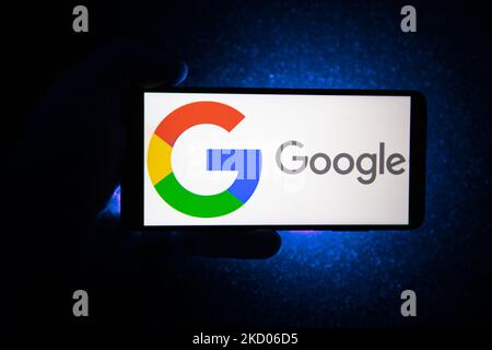 Hand hält ein Smartphone mit dem angezeigten Google-Logo und dunkelblauem Hintergrund. Google-Closeup-Logo auf einem Telefonbildschirm, Smartphone das Logo oder die Suchmaschine in verschiedenen Hintergründen wie Tastatur, dunkel beleuchtete Textur oder ein Computerbildschirm angezeigt, wie in dieser Multiple-Exposure-Illustration gesehen, das Unternehmenssymbol ist weltweit anerkannt. Google, LLC ist ein amerikanischer Tech-Gigant, ein multinationales Technologieunternehmen, das sich auf internetbezogene Dienste und Produkte spezialisiert hat, zu denen Online-Werbetechnologien, eine Suchmaschine, Cloud-Computing, Software und Hardware gehören. Es ist c Stockfoto