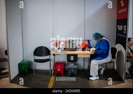 Krankenschwestern bereiten am 12. Januar 2022 im größten Impfzentrum Kolumbiens, das sich auf dem Parkplatz von Corferia in Bogota, Kolumbien befindet, Spritzen und Papierkram für Personen vor, die gegen COVID-19 geimpft werden, wo Kinder und Erwachsene ihre ersten Dosen von Moderna und Booster von SINOVAC- und AstraZeneca-neuartigen COVID-19-Impfstoffen erhalten. (Foto von Sebastian Barros/NurPhoto) Stockfoto