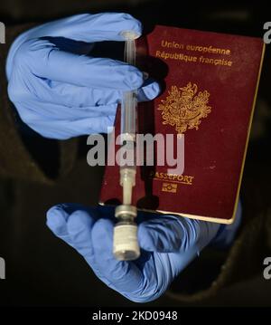 Ein illustratives Bild einer Person mit einer medizinischen Spritze und dem Pfizer-BioNTech Covid-19-Impfstoff neben einem französischen Pass. Am Mittwoch, den 12. Januar 2021, Kanada. (Foto von Artur Widak/NurPhoto) Stockfoto