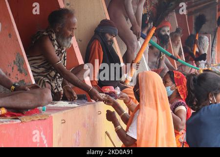 Ein Sadhu (hinduistischer heiliger Mann) segnet einen Pilger während des Gangasagar Mela inmitten steigender Fälle von COVID-19 auf der Insel Sagar, etwa 150 km südlich von Kalkutta, Indien, am 13.. Januar 2022. (Foto von Debajyoti Chakraborty/NurPhoto) Stockfoto