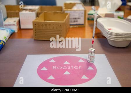 Nahaufnahme eines Fläschchens mit einer Nadel und der Auffrischungsbeschriftung. GGD, Mitarbeiter im öffentlichen Gesundheitswesen, bereitet die Impfstoffe der Moderna Spikevax mRNA Covid-19 vor, die sie aus der Glasflasche in Fläschchen zu individuellen Dosen in den Spritzen im Sondergebiet des Mega-Impfzentrums in Eindhoven ziehen. Die Jabs werden als Booster-Schuss verabreicht. Der dritte Dosisverstärker ist für alle in den Niederlanden verfügbar, zusätzlich zur Sperrung, da das Land gegen Ausbrüche der neuen omicron-Variante-Coronavirus-Mutation der Pandemie kämpft. Eindhoven, Niederlande am 7. Januar 2022 (Foto: Nicolas Economou/N Stockfoto