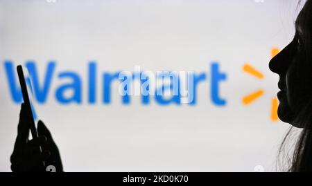 Ein Bild einer Frau, die ein Mobiltelefon vor das Walmart-Logo hält, das auf einem Computerbildschirm angezeigt wird. Am Dienstag, den 12. Januar 2021, Kanada. (Foto von Artur Widak/NurPhoto) Stockfoto