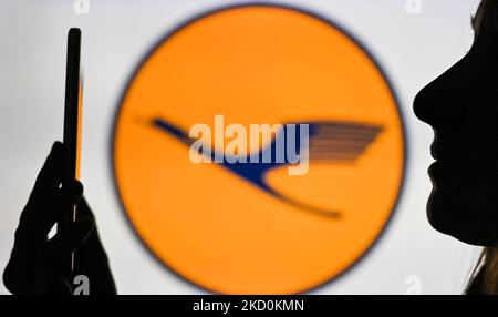 Ein Bild einer Frau, die ein Mobiltelefon vor das Lufthansa-Logo hält, das auf einem Computerbildschirm angezeigt wird. Am Dienstag, den 12. Januar 2021, Kanada. (Foto von Artur Widak/NurPhoto) Stockfoto