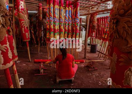 Ein Arbeiter malt einen großen Räucherstäbchen zum Verkauf vor den Feierlichkeiten zum Neujahrsfest in einer Heimatfabrik am 18. Januar 2022 in Medan, Indonesien. Ethnische Chinesen im bevölkerungsreichsten muslimischen Land der Welt bereiten sich auf das chinesische Mondjahr des Tigers am 01. Februar vor. Als Teil von Weihrauch ist ein komplettes chinesisches Neujahrsgebet, das aus Drachenräuchern aus gesägtem Holzpulver mit Holzleim-Klebstoff hergestellt wird. Danach wird sie in Form einer Rolle gedruckt, dann monatelang in der Sonne getrocknet, gefolgt von einem roten Farbstoff, dann wird der Drachenschmuck manuell gedruckt. (Foto von Ivan Damanik/NurPhoto) Stockfoto